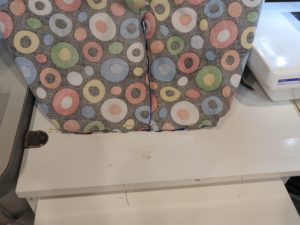 Photo of bottom of corner of laminated cotton beach bag pinned and ready to sew.