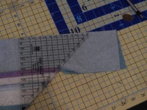 Mastering Miters: How to Sew A Mitered Quilt Border 11 Photo of straight edge aligned with diagonal of quilt to create a mitered quilt border