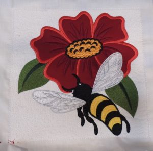 Photo of final embroidery design with flower appliqué