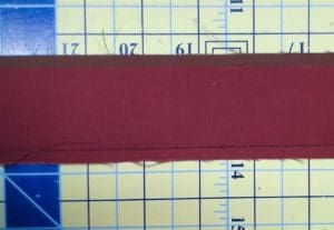 Make your Quilt Pop With Flange Binding 6 Photo of flange binding with red and brown strips sewn together along long end.