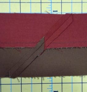 Make your Quilt Pop With Flange Binding 8 Photo of wrong side of red and brown flange binding showing seams that connect strips from end to end.