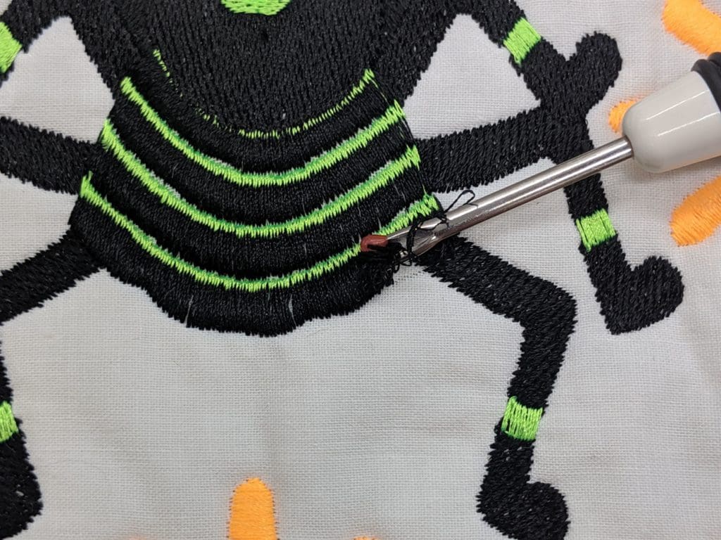 The Fringe Element: Add Some 3-D Interest to Embroidery 14 Photo of seam ripper lifting satin stitches up to create fringe