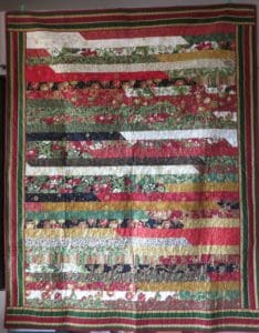 Ready, Set, Sew! A Jelly Roll Race at Rocky Mountain's Colorado Springs Store 10 Photo of Jelly Roll Race quilt with border made of red, gold and black christmas-themed fabrics.