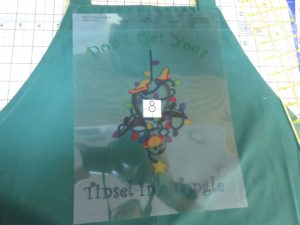 Photo of transparency placed on apron with snowman placed on the center of the design.