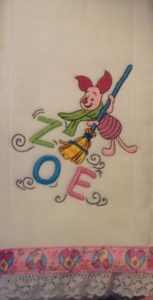 Photo of pre-folded diaper embroidered for a burp cloth featuring piglet