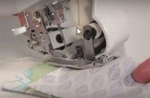 Don't Get Ruffled, Get Ruffling: Gather Fabric Using a Serger 8 Photo showing when you gather fabric using a serger you place the flat fabric in the groove on the foot on top of the ruffle fabric